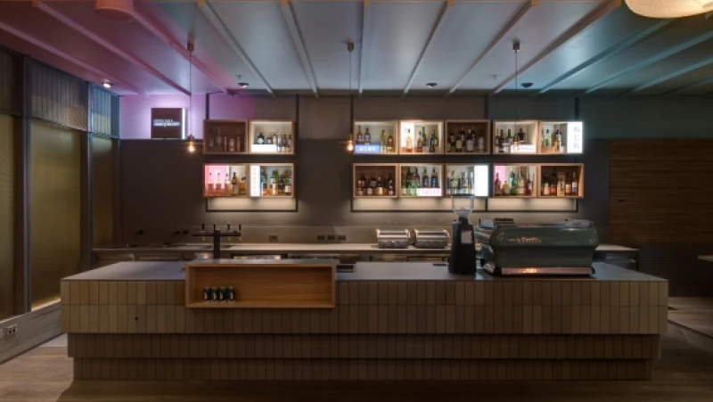 Darkened bar with alcohol bottles on shelf behind