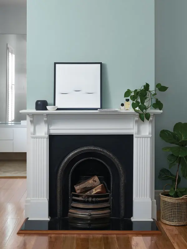 Green-blue fireplace with white mantlepiece