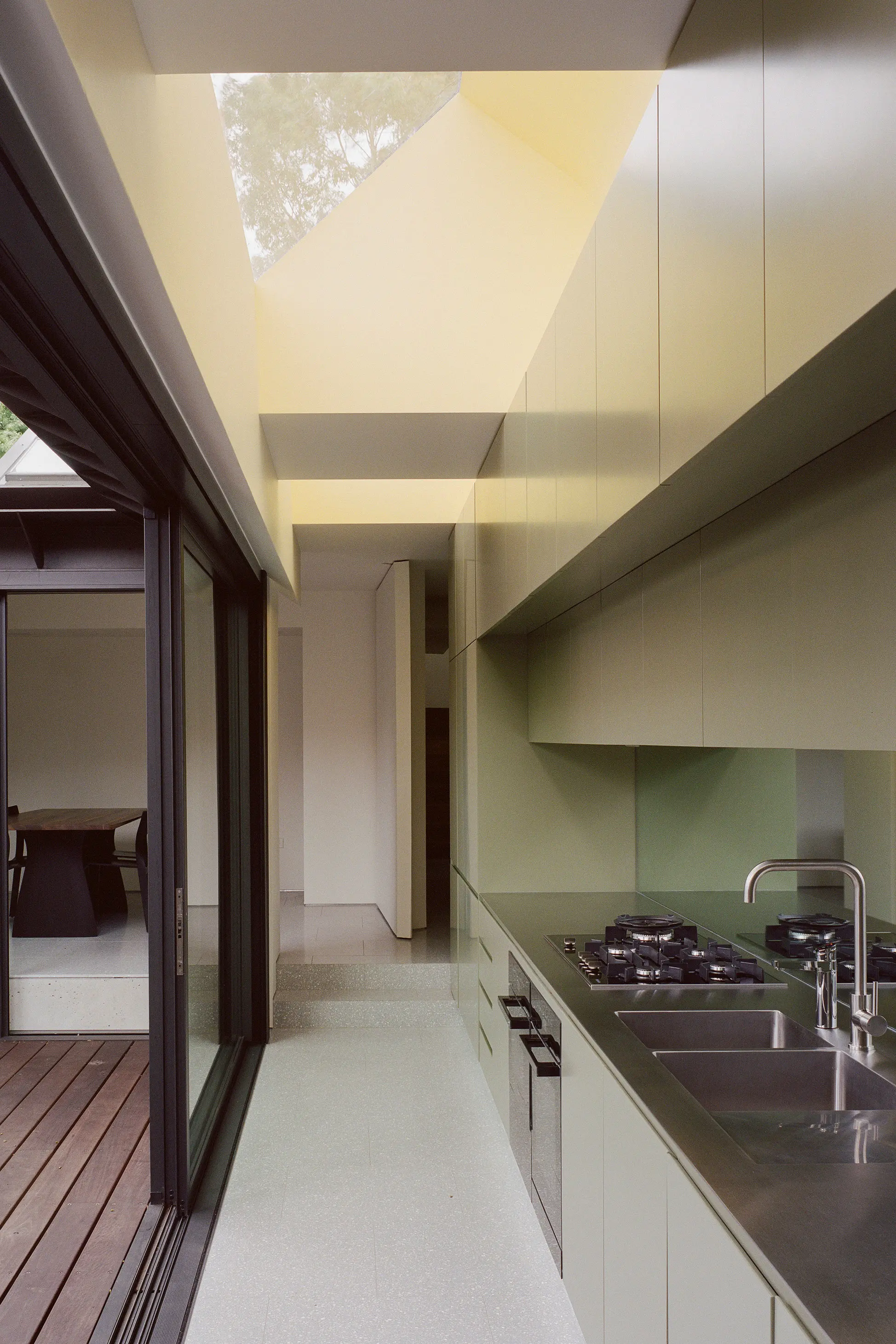 Green kitchen with sliding doors onto deck.