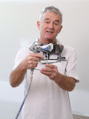 Trade painter demonstrating how to hold a paint spray gun