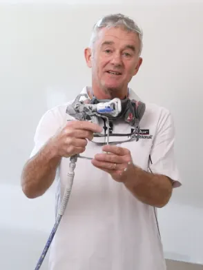 Trade painter demonstrating how to hold a paint spray gun