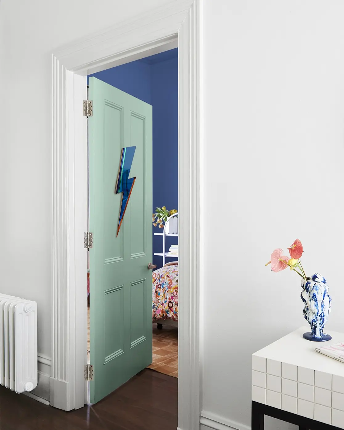 Green hall door leading into a blue bedroom. 