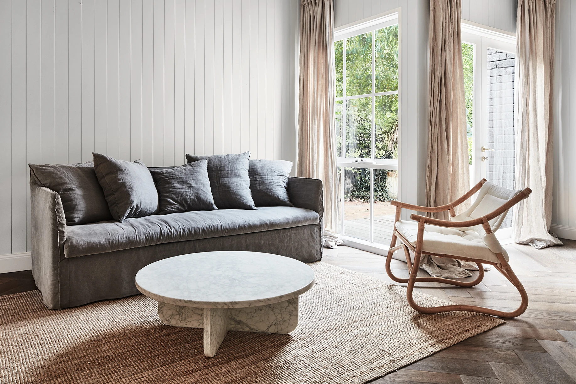 White living room with VJ panelled walls, sofa and coffee table.