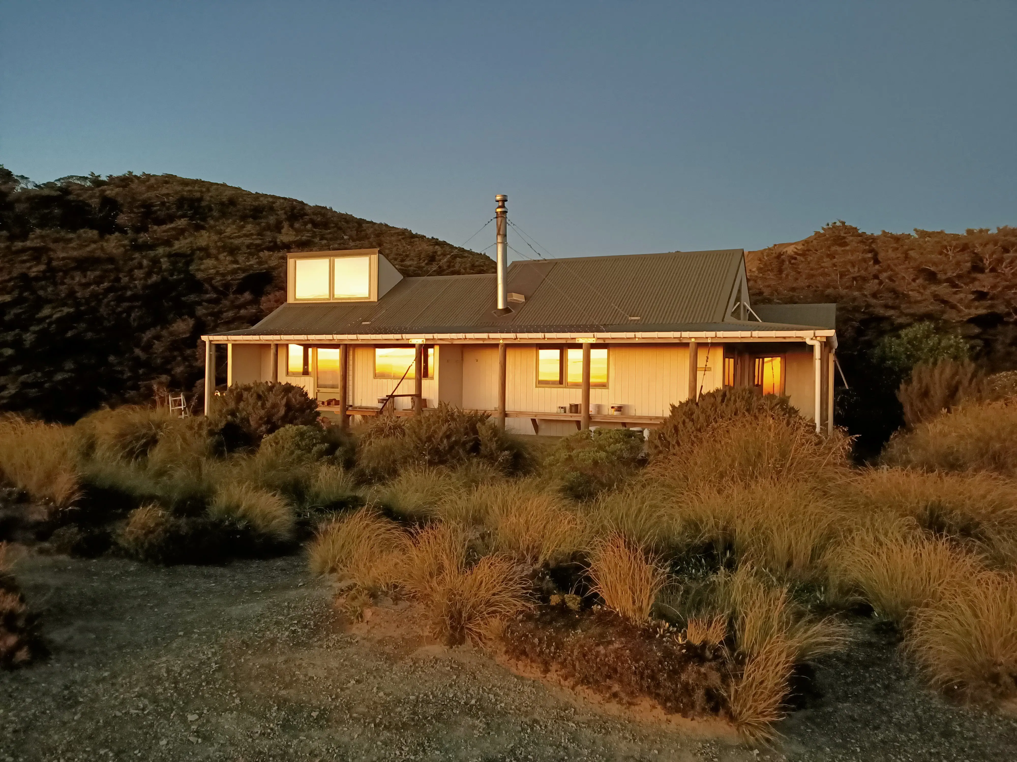 Sunrise Hut pictured with the sun rising reflecting in the windows