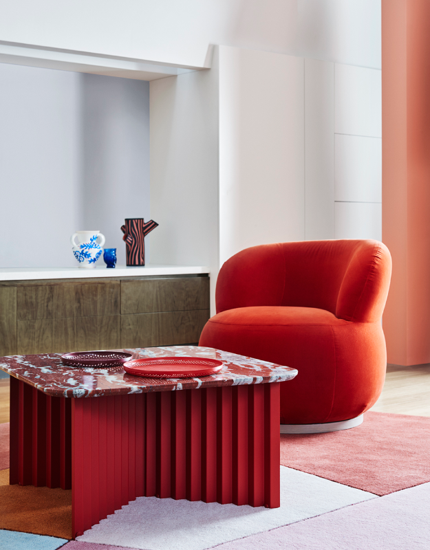 A red shell chair in living room with modern coffee table