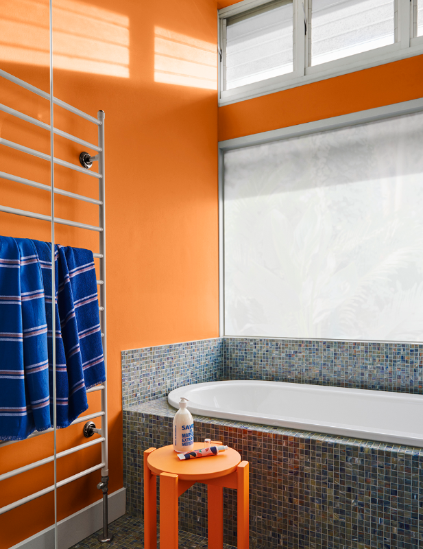 Orange bathroom with full bath and towel heating bars