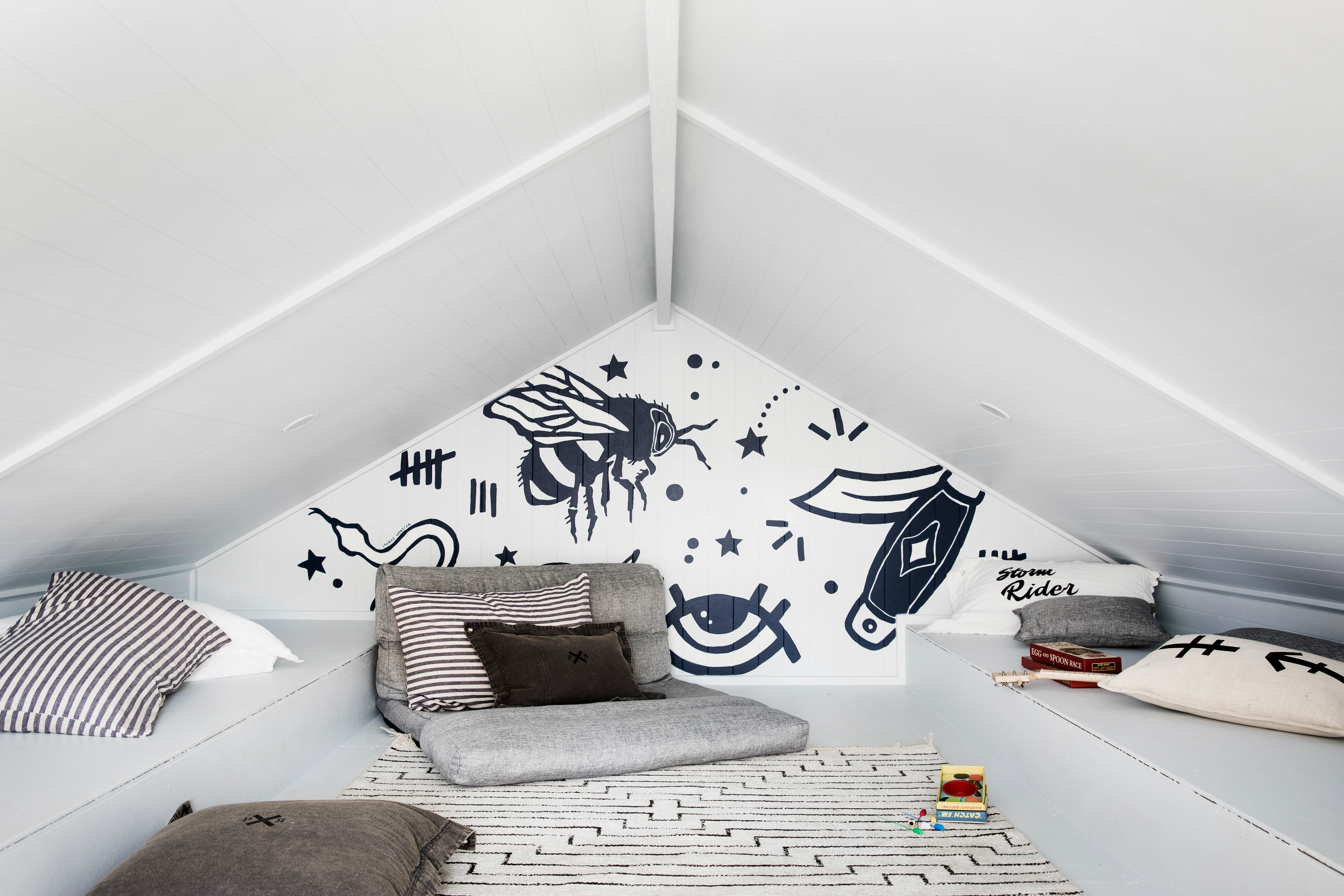 white attic with black and white cartoon feature wall