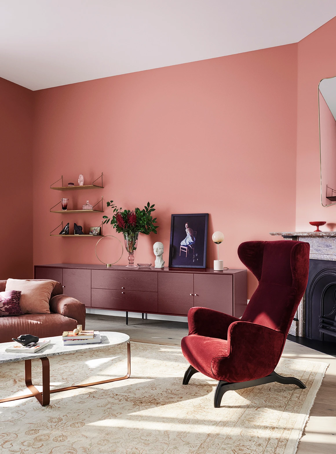 interior pink lounge room, with red velvet chair. 