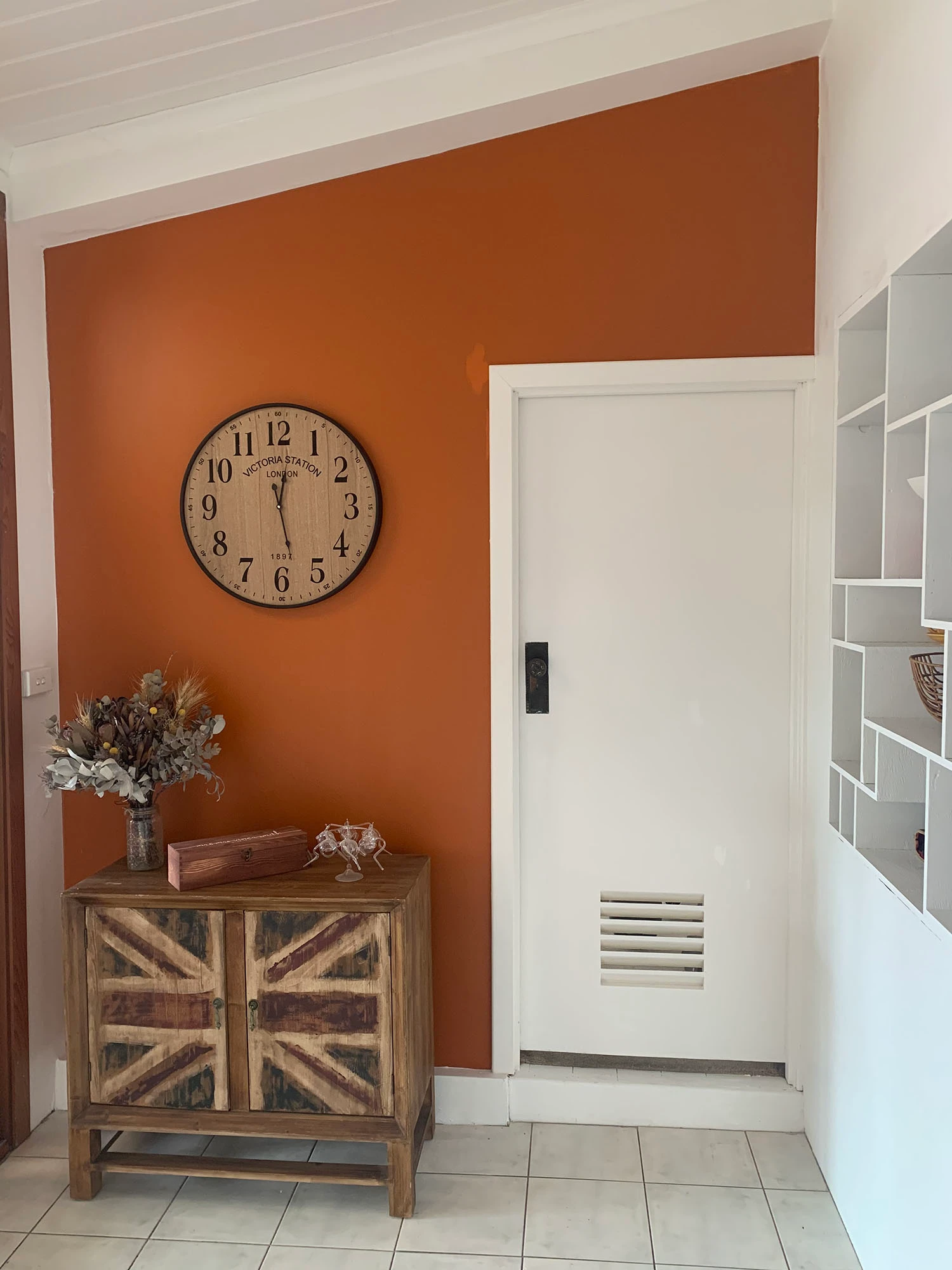 Rust-coloured living room with white door and ceiling.