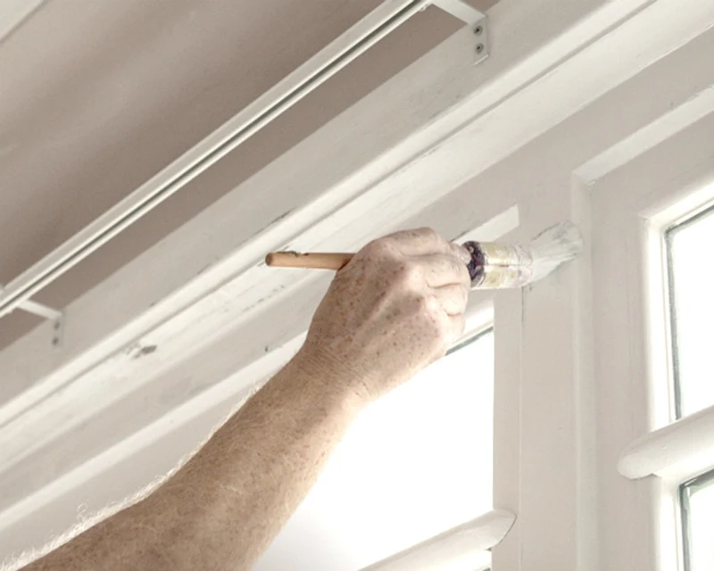 Woman working on white trims and grey wall