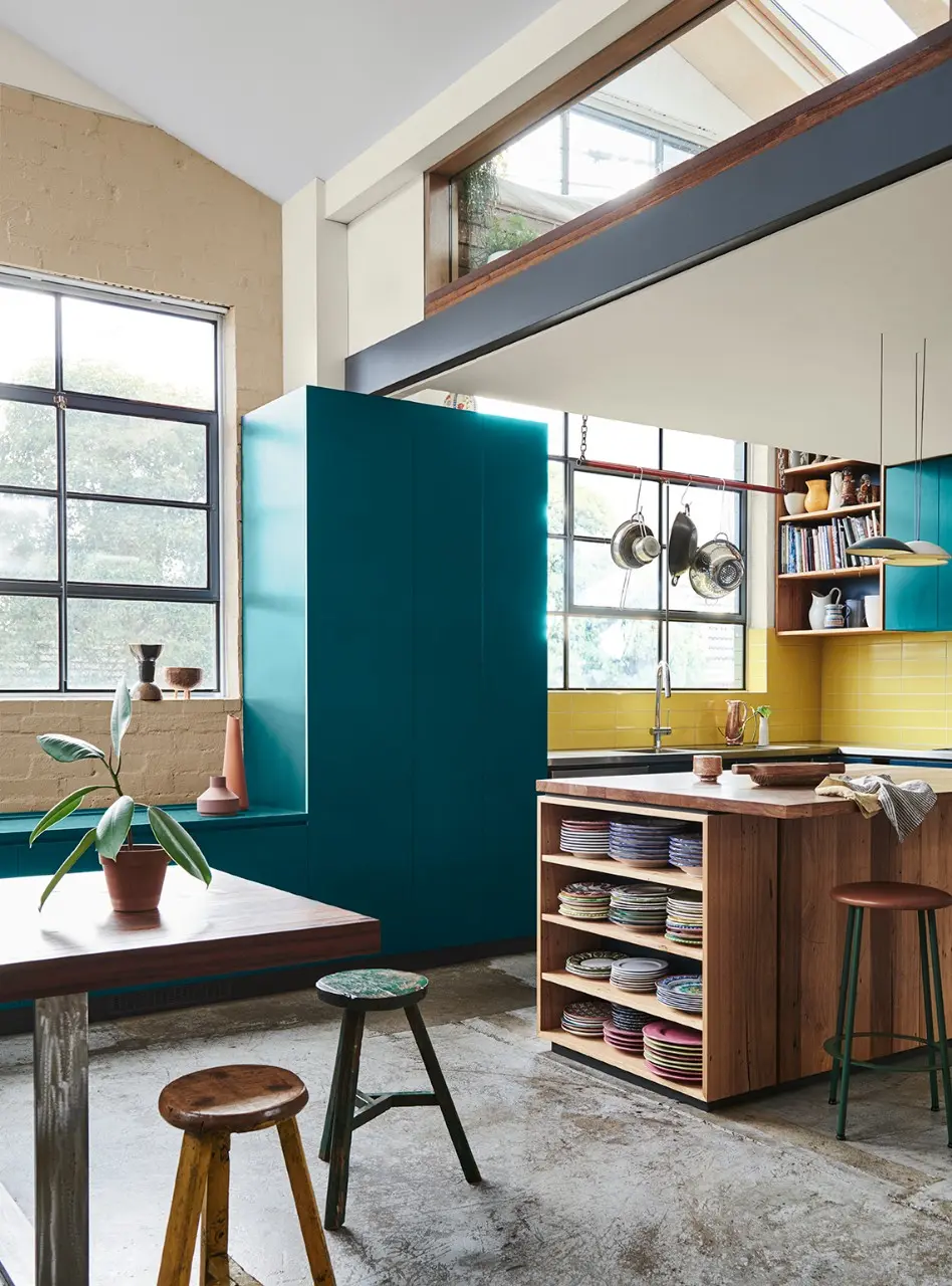 interior teal kitchen with stools and shelves.