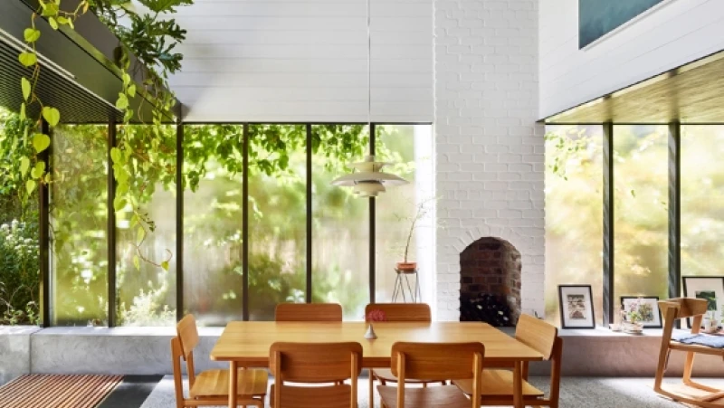 White dining room with fireplace and large windows