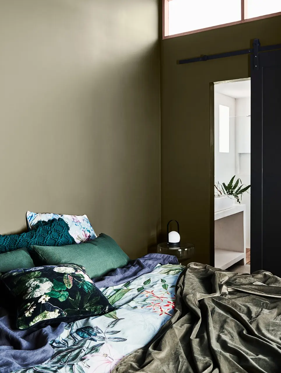 interior bedroom with green and blue bedding.