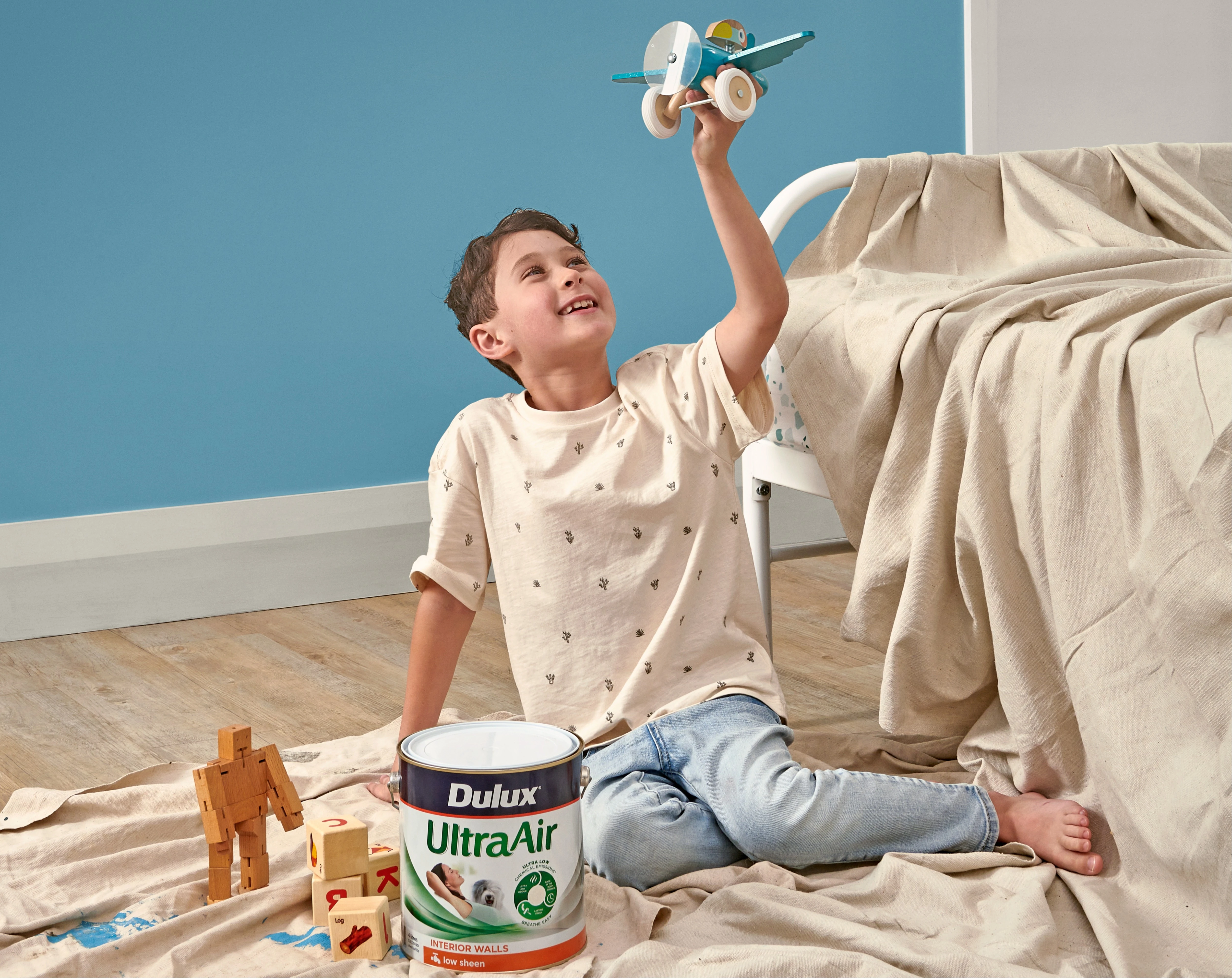 Kid's bedroom, grid bedding, bunny toy and white wall with blue half.