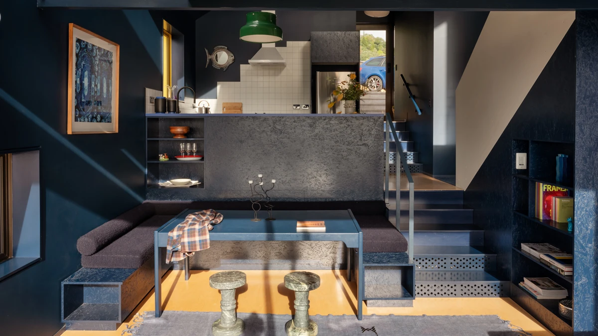 Kitchen with stone benchtop, and a sitting area with sun streaming onto it