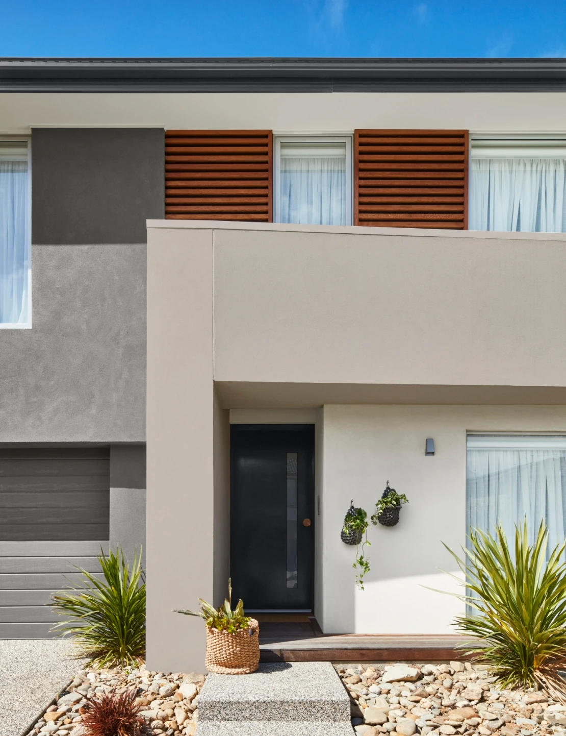 A Two story home exterior built from multiple materials with a Two Tone colour scheme 