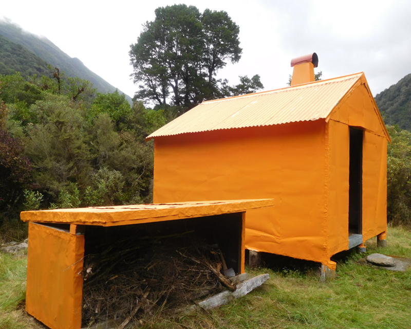 Top Crooked Hut is bright orange and has a small structure next to it that holds firewood