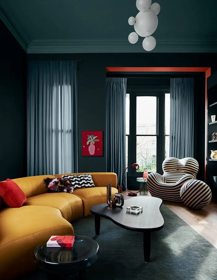 Living room with dark blue walls and a yellow couch