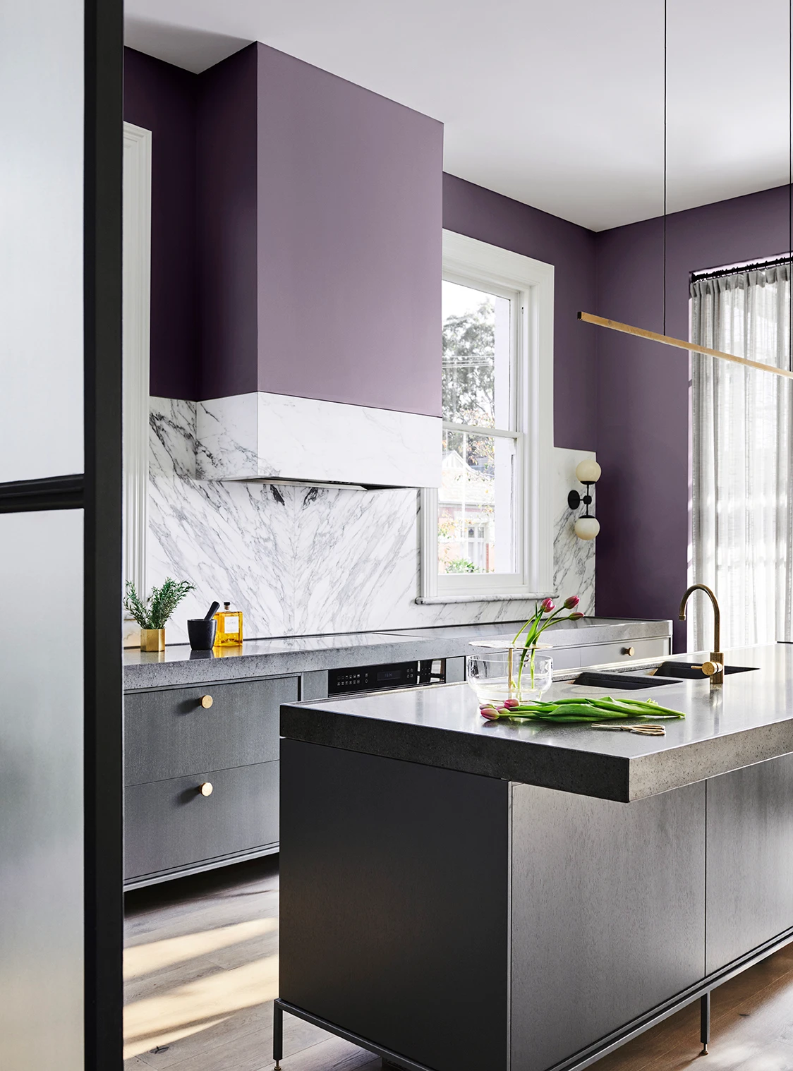 interior purple kitchen and black island bench. 