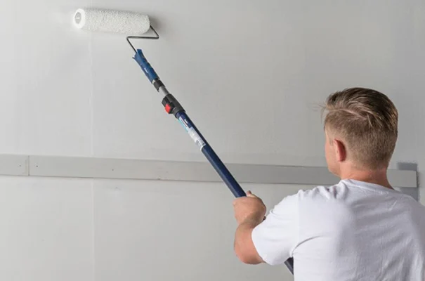 Man painting wall with roller