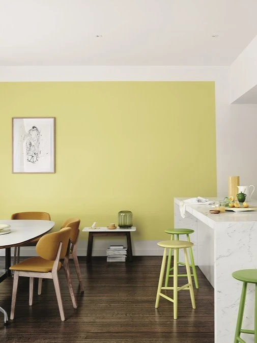 Yellow wall featuring in dining room with decorative items on table and buffet.