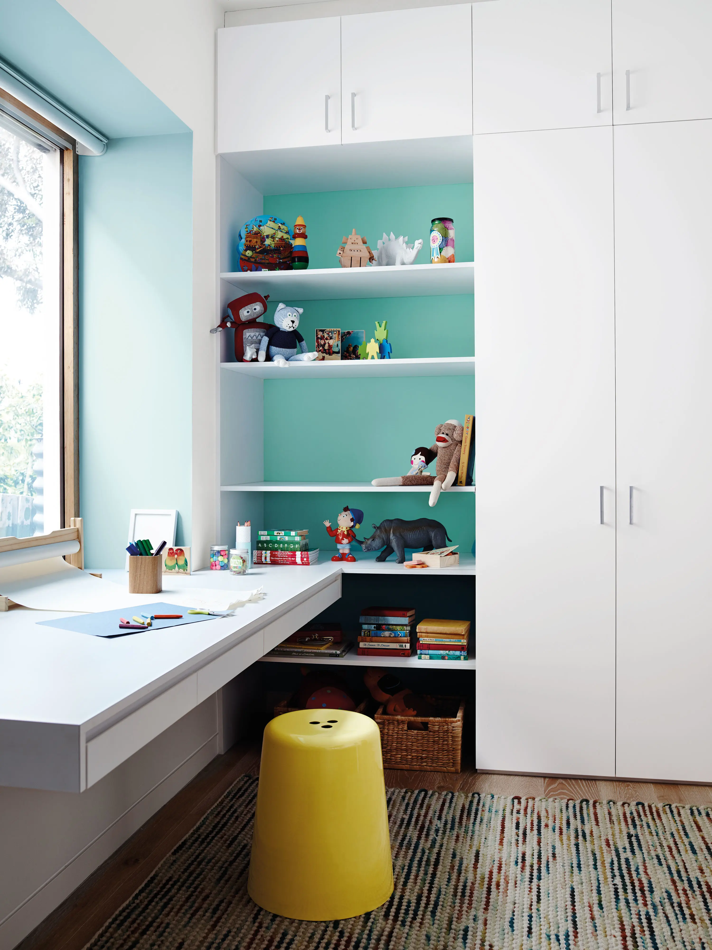 Kids bedroom with bunk beds, table, chairs and assortment of decorations.