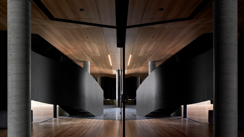 interior setting, mirrored black staircases with wooden ceiling and floor.