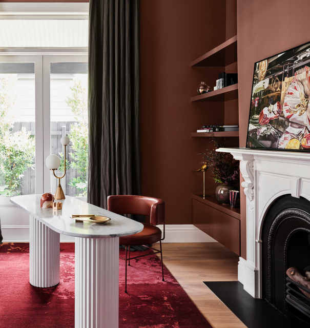 Brown study with a white fireplace and desk