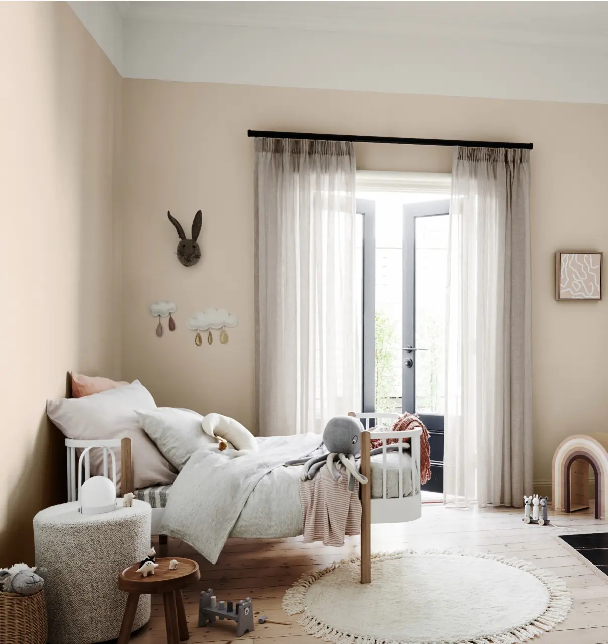 Cream and white kid's bedroom with various decorative items and furniture.