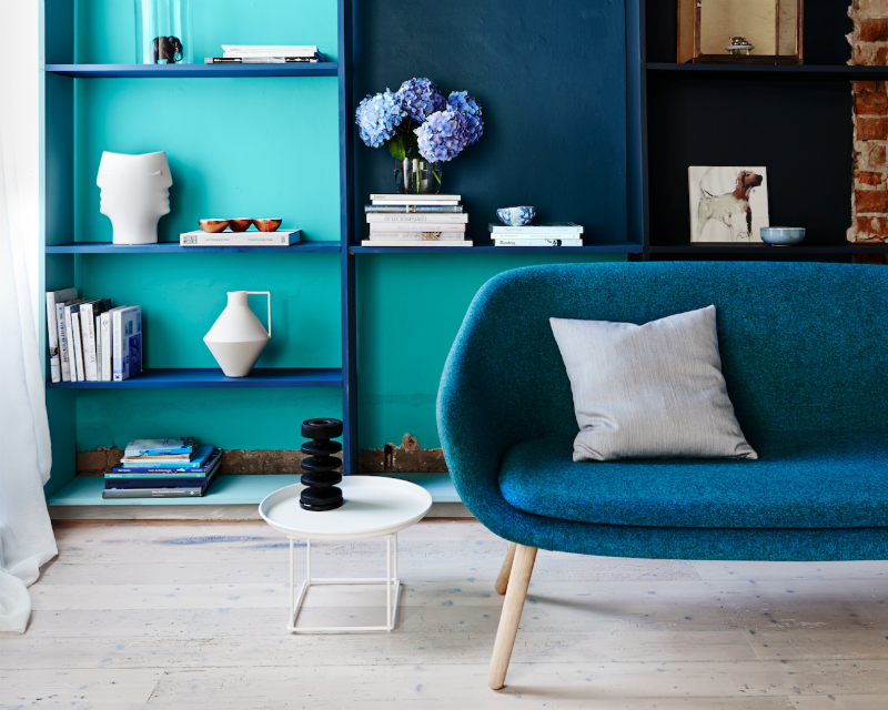 Blue lounge against color blocked blue bookcase