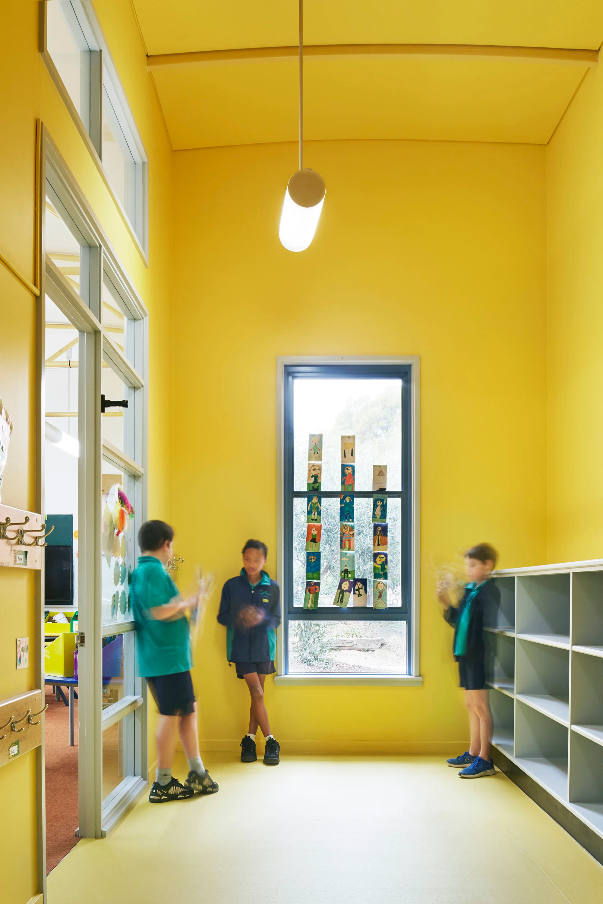 Classroom storage area with three students.