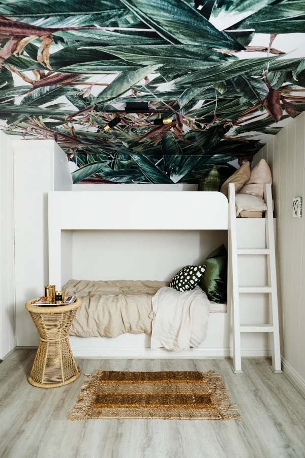 Palm wallpaper used on ceiling. Neutral bunk beds and walls in Dulux Parchment Paper. Cane side table.