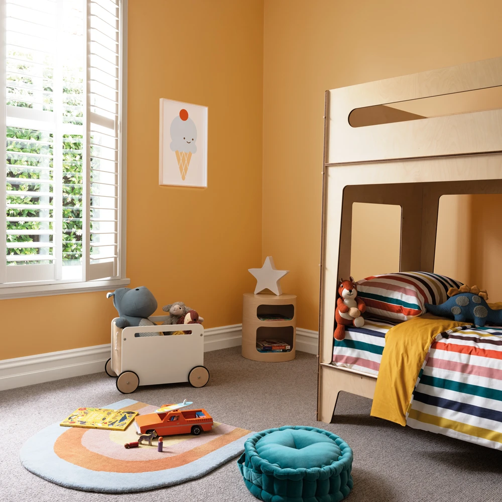 Yellow kid's bedroom with bunk bed and toys on floor.