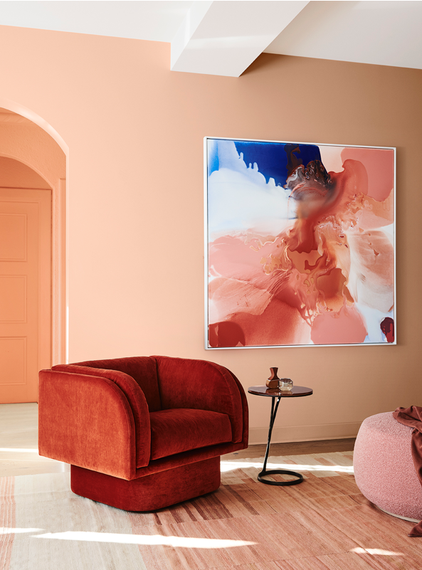 an orange arm chair in a pink coloured seating area 