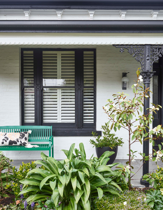 White Victorian house with black veranda posts and window trim