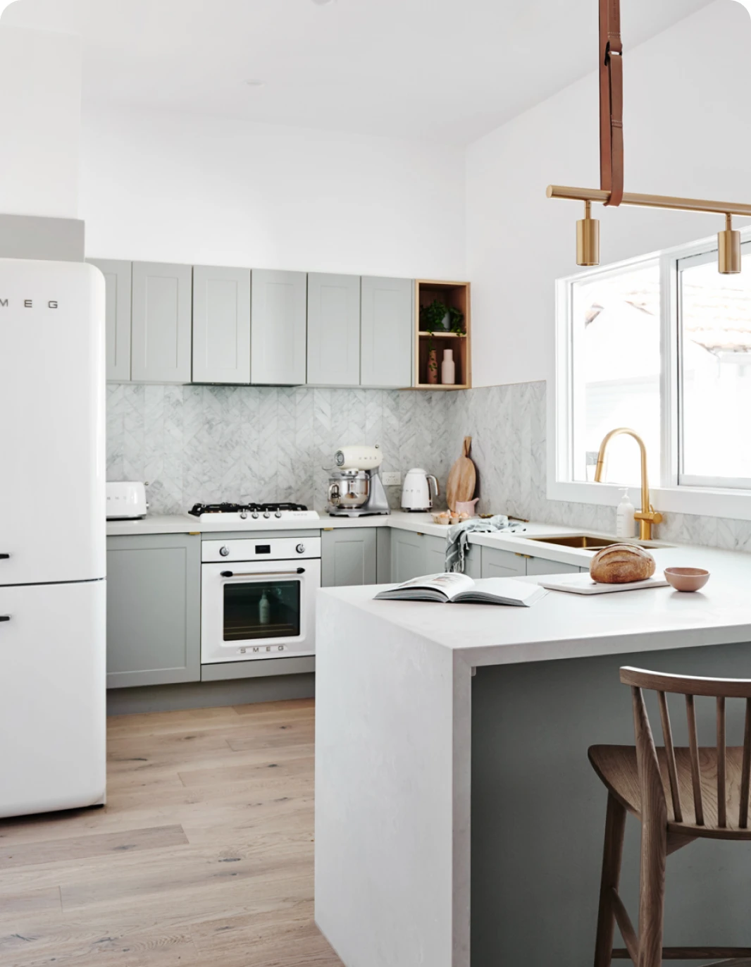 Neutral coloured kitchen with white Smeg fridge and wooden floor