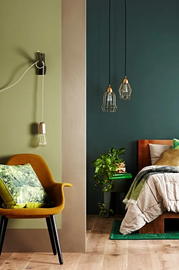 Green bedroom with clear pendant lights.