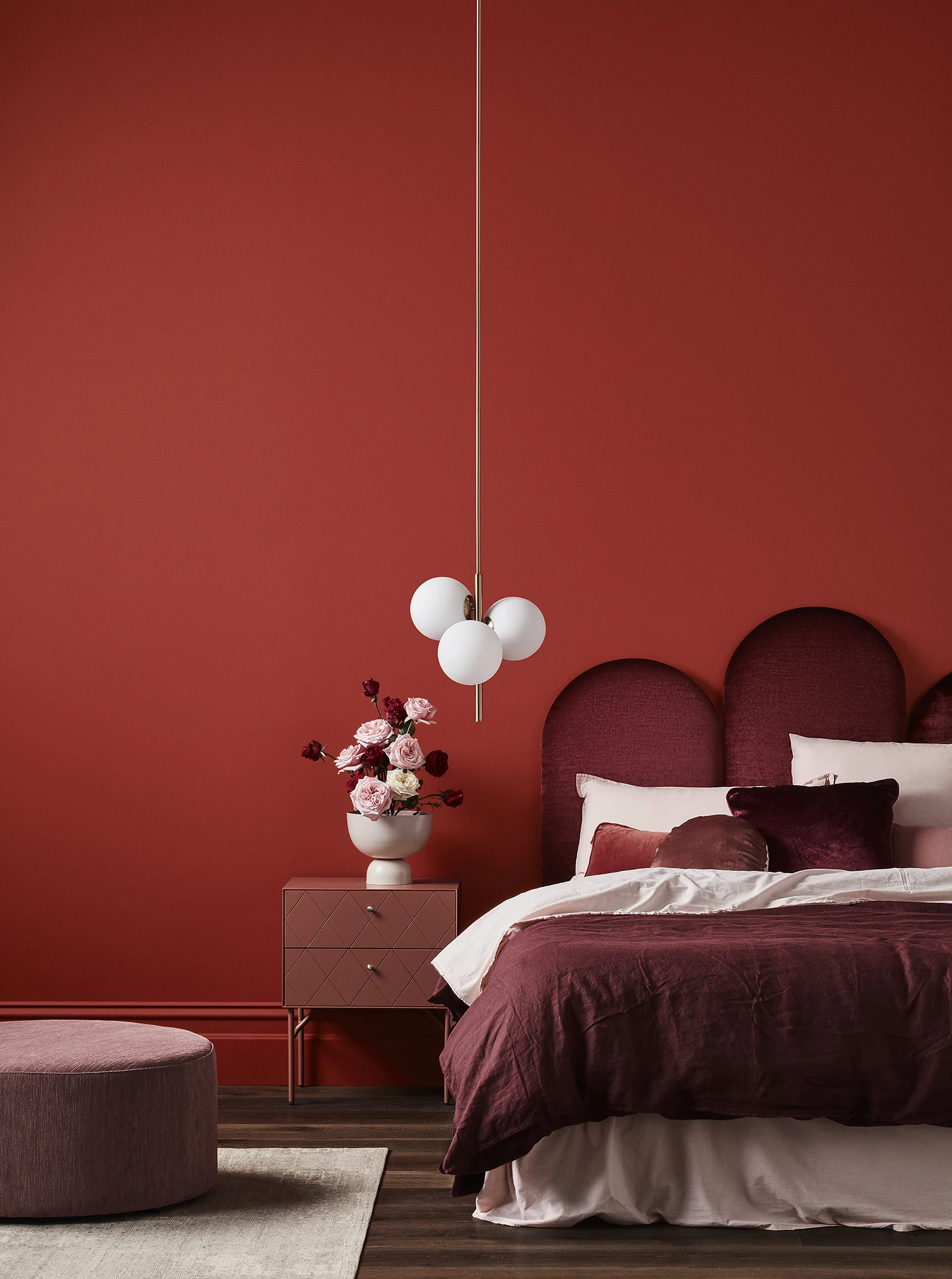 Bedroom w/ dark red walls, terracotta decor