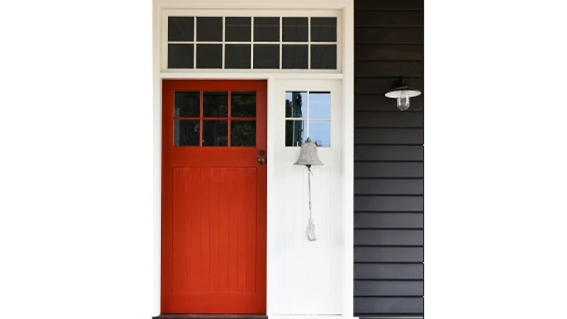 Grey weatherboard house with white trim and red door