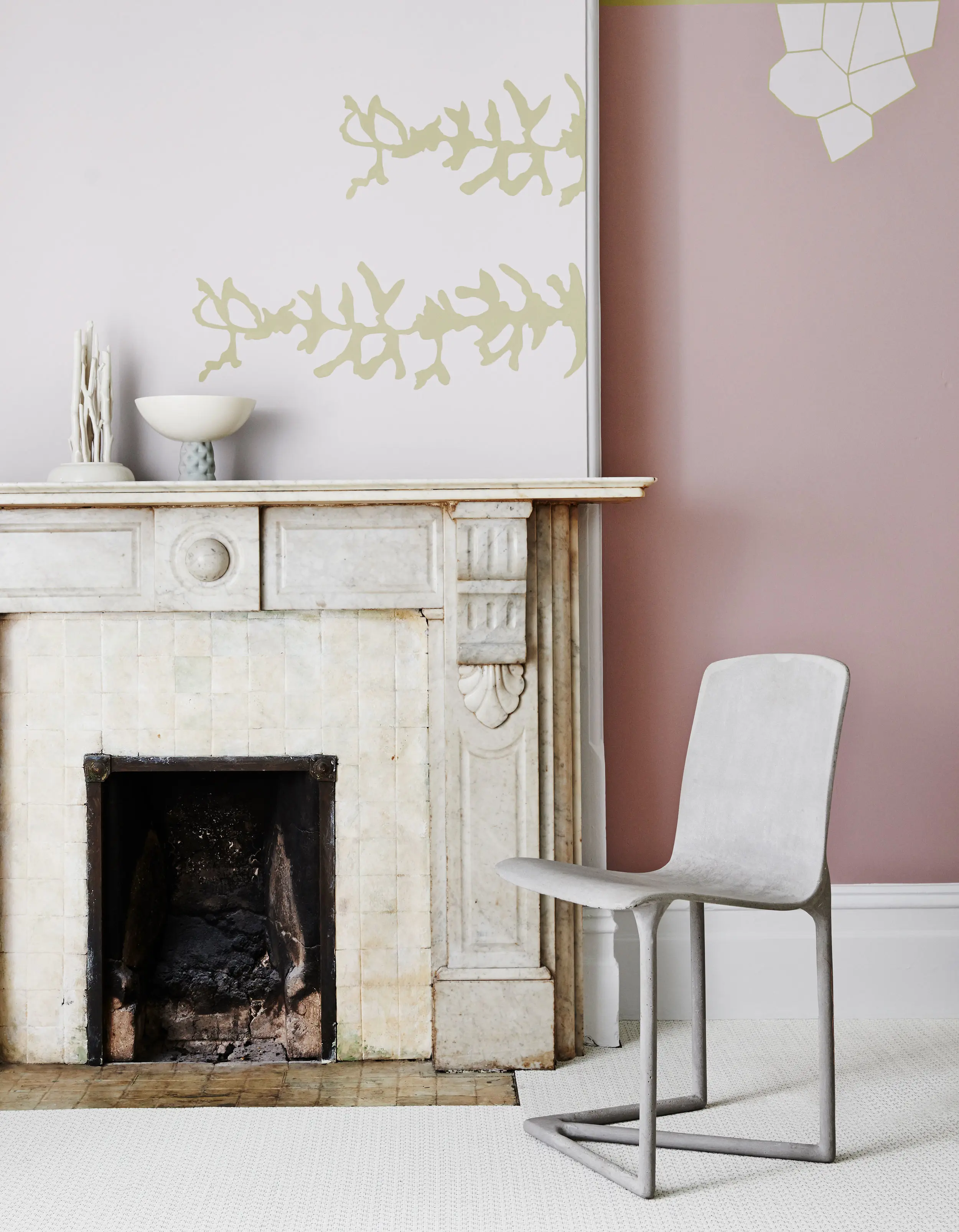 White fireplace in pink room with chair