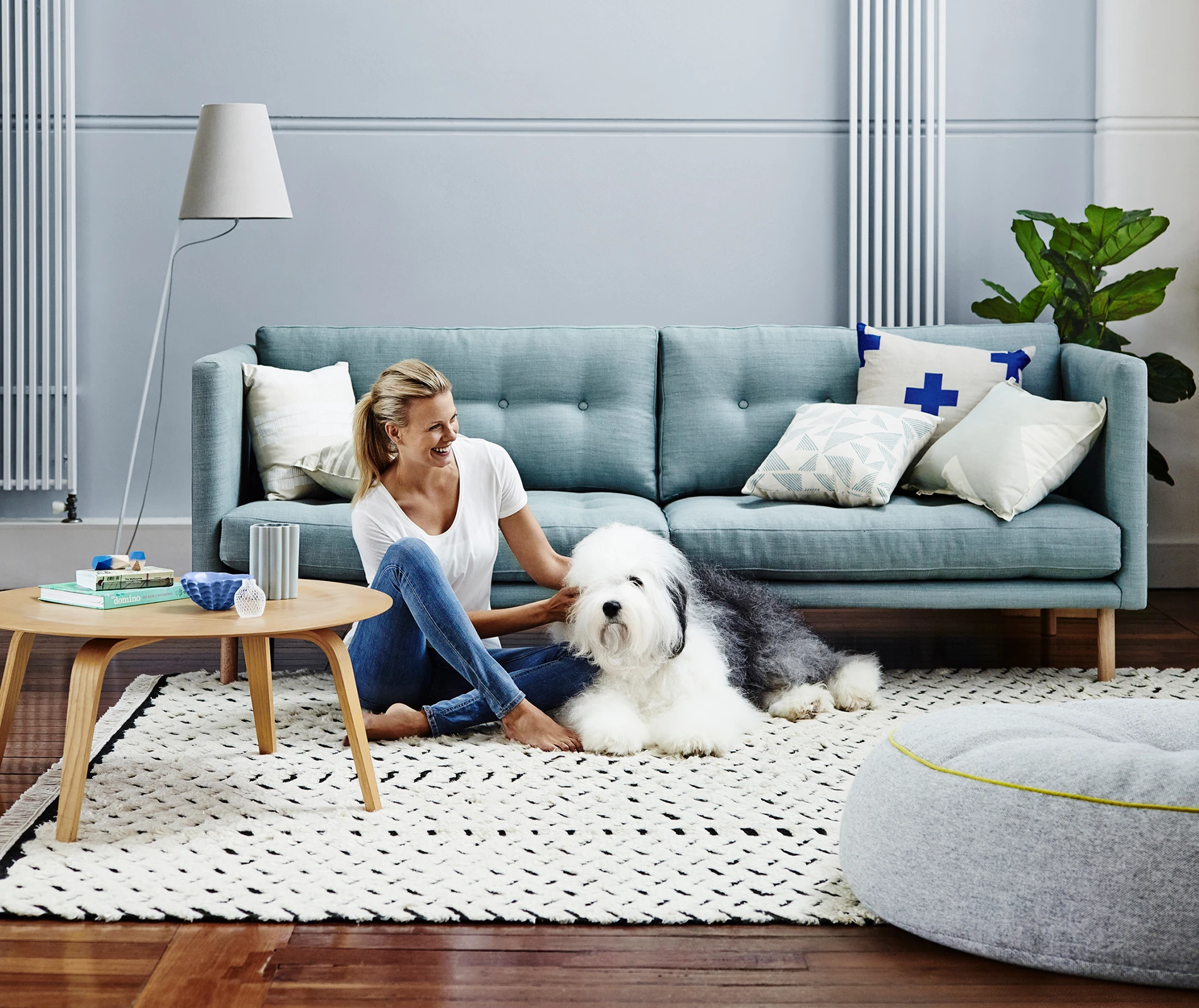Woman and dog on floor in blue living room with blue couch