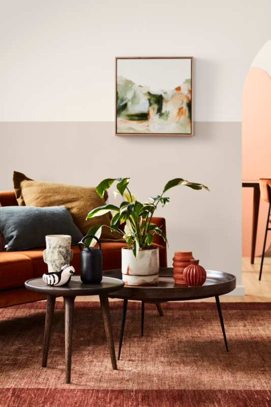 Living room with wooden round coffee tables with plants and vases on them