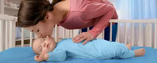 Mamá aplicando Vick BabyRub a su bebé