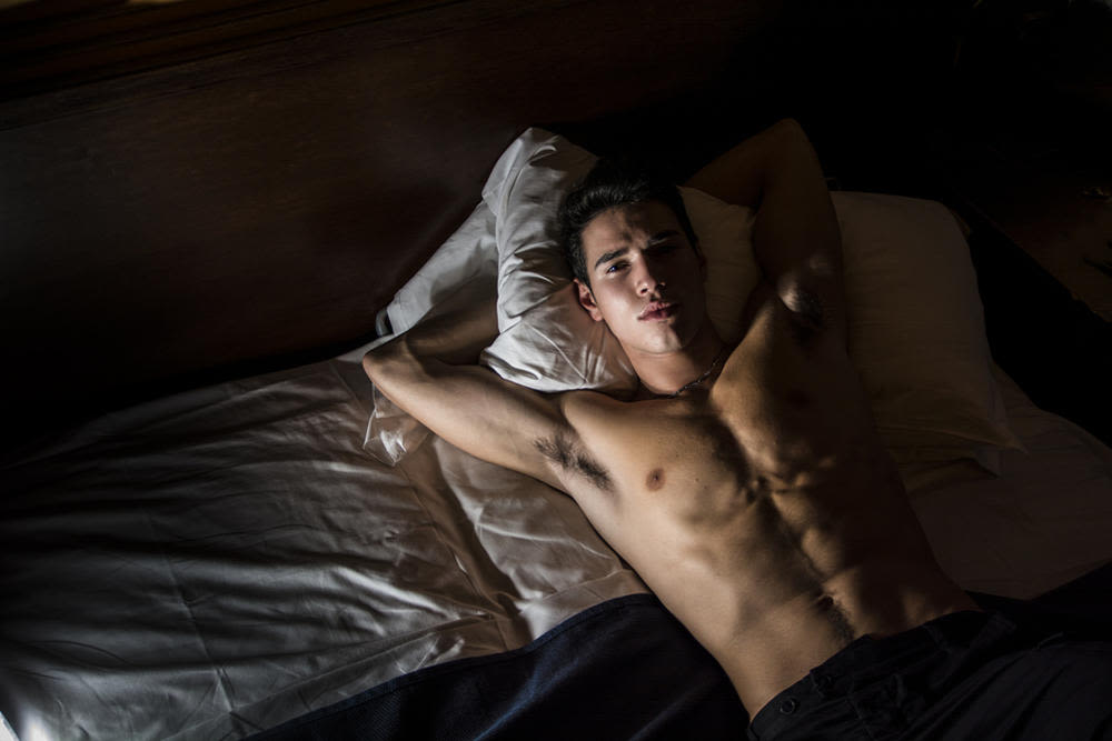 man lying on bed shirtless