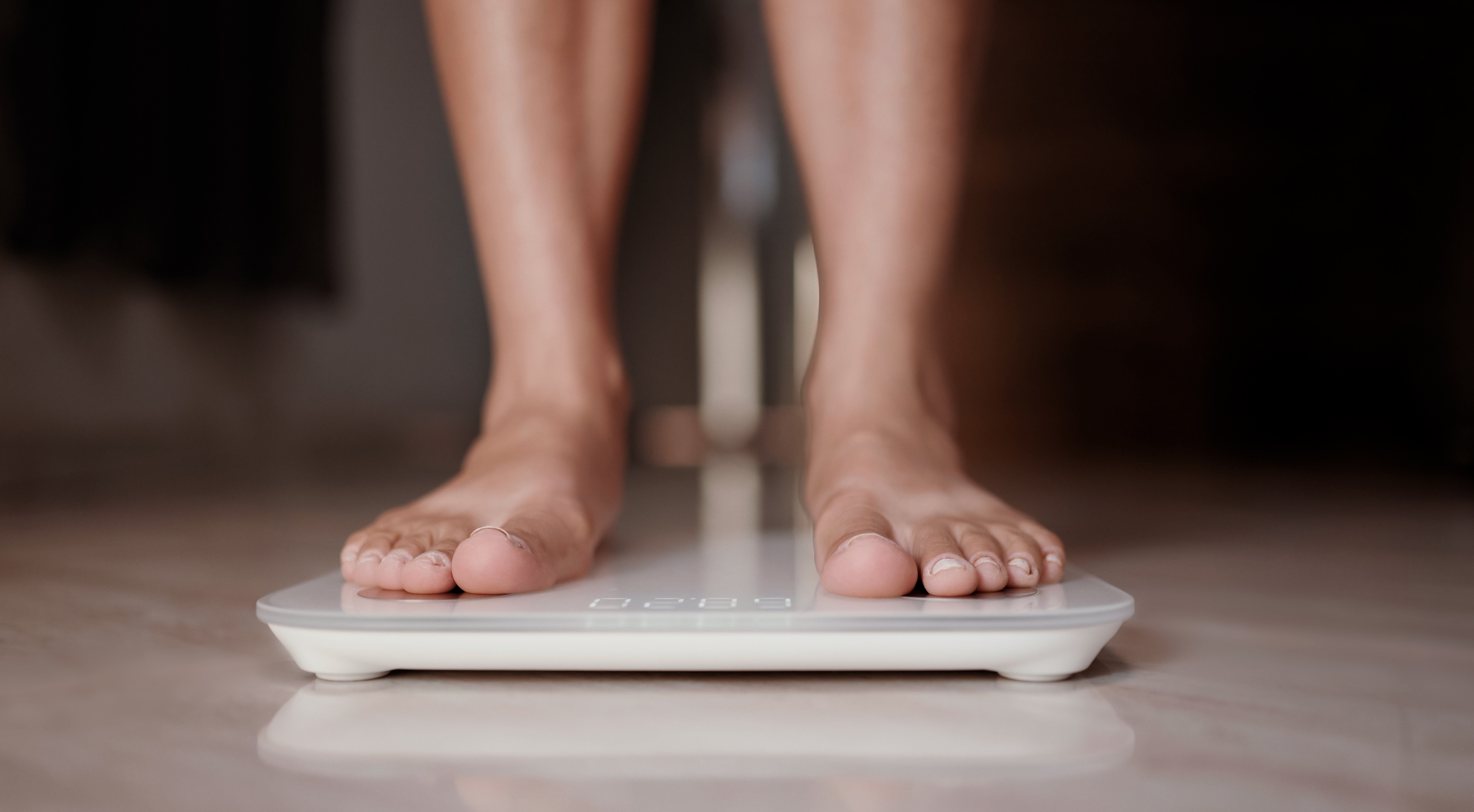 A close-up of two feet standing on a scale