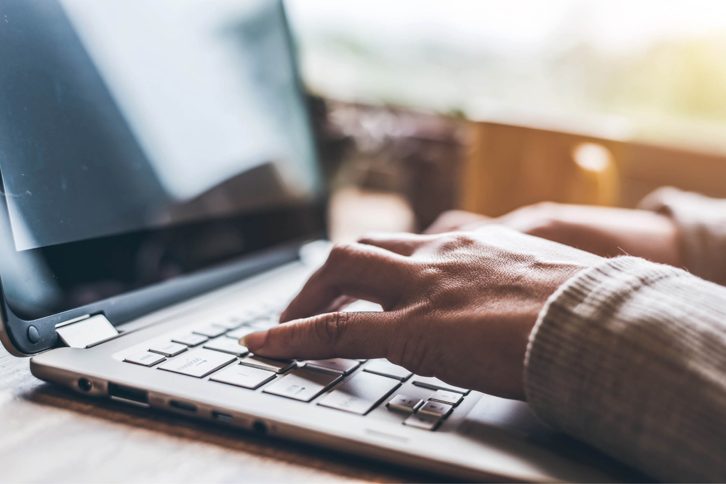 A pair of hands typing on a laptop keyboard