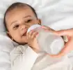 Bebé tomando leche en mamadera.