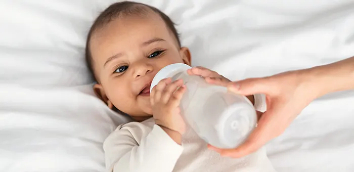 Bebé tomando leche en mamadera.
