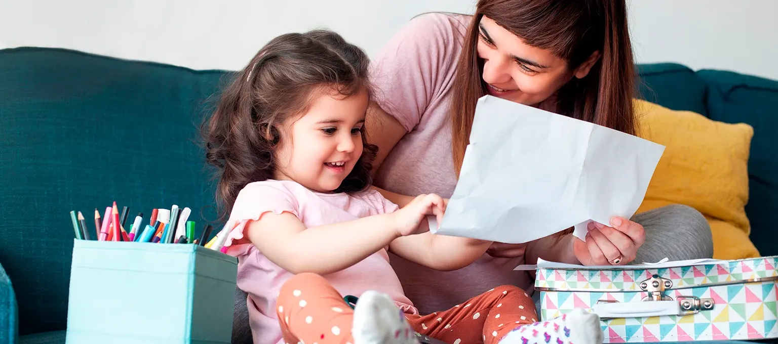 Niña dibujando con su mamá