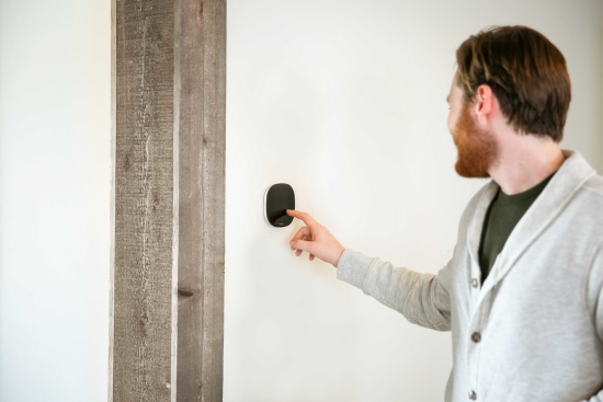 Man operating an ecobee smart thermostat inside home